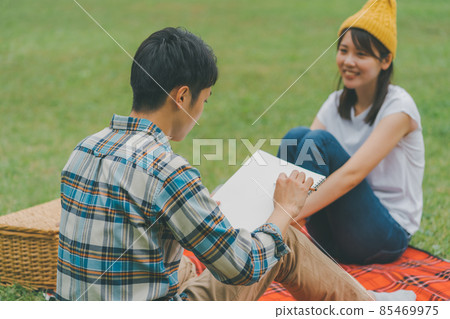 Boyfriend drawing her caricature in the park Boyfriend drawing her caricature in the park 85469975