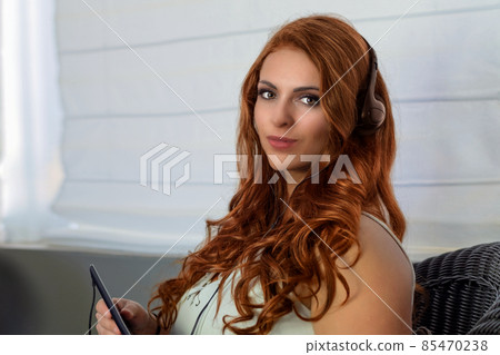 redhead woman music listening beautiful hairs headphones and phone relaxing lifestyle 85470238