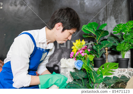 Japanese man wearing an apron to care for flowers 85471123