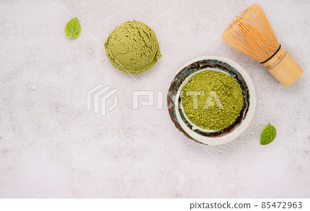 Matcha green tea ice cream with green tea powder and mint leaves setup on white stone background . Summer and Sweet menu concept. Matcha green tea ice cream with green tea powder and mint leaves setup on white stone background . Summer and Sweet menu concept. 85472963