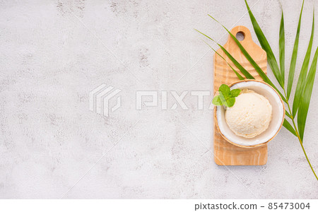 Coconut ice cream flavours in half of coconut setup on white stone background. Summer and Sweet menu concept. Coconut ice cream flavours in half of coconut setup on white stone background. Summer and Sweet menu concept. 85473004