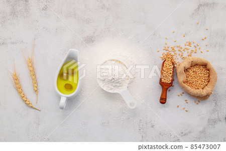The ingredients for homemade pizza dough with wheat ears ,wheat flour and olive oil set up on white concrete background. top view and copy space. 85473007