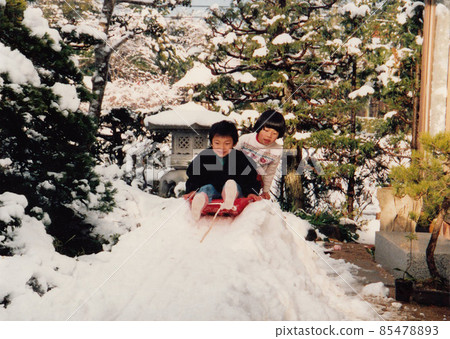 一個男孩在雪橇上玩耍,冬天積雪 一個男孩在雪橇上玩耍,冬天積雪 85478893