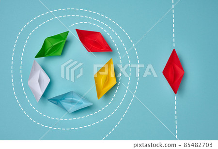 a group of paper boats floats in a circle, another red floats in a straight line. Strong leader concept, different vision, strong business. Looping over an idea 85482703