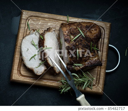 baked piece of pork meat in spices on a wooden board, cut into pieces. Eye of round roast steak baked piece of pork meat in spices on a wooden board, cut into pieces. Eye of round roast steak 85482717