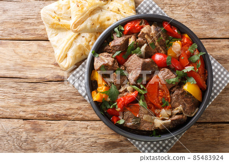 Delicious buglama meat stewed with vegetables and herbs in its own juice close-up in a bowl. horizontal top view 85483924