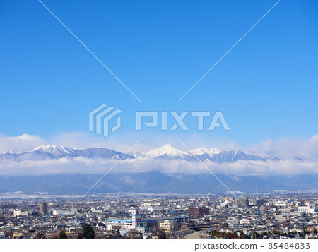 January (winter), the cityscape of Matsumoto seen from a hill and the cloudy Northern Alps Matsumoto City, Nagano Prefecture 85484833