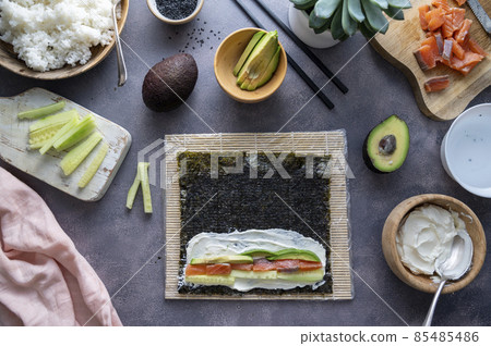 Cooking Sushi rolls at home with salmon, avocado and cucumber, step by step. 85485486