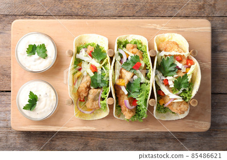 Yummy fish tacos served on wooden table, top view Yummy fish tacos served on wooden table, top view 85486621