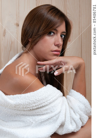 young woman in a sauna or spa after a treatment with her bathrobe 85486781