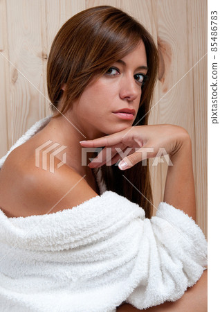 young woman in a sauna or spa after a treatment with her bathrobe young woman in a sauna or spa after a treatment with her bathrobe 85486783