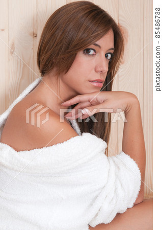 young woman in a sauna or spa after a treatment with her bathrobe 85486788