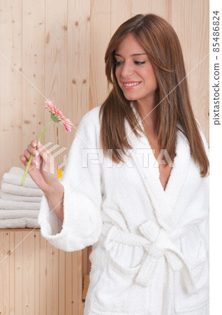 young woman in a sauna or spa after a treatment with her bathrobe 85486824