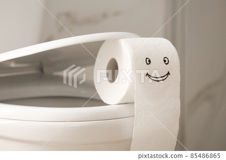 Roll of paper with funny face on toilet bowl in bathroom, closeup Roll of paper with funny face on toilet bowl in bathroom, closeup 85486865