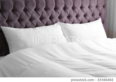 Modern bed with soft pillows in room 85486868