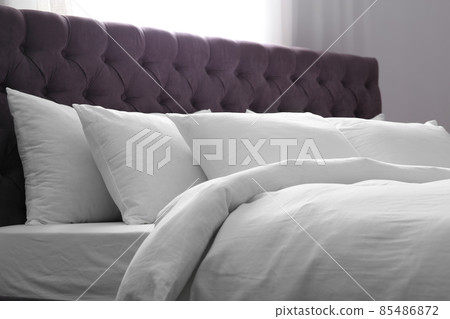 Modern bed with soft pillows in room 85486872