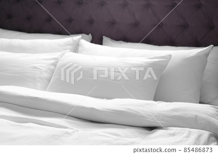 Modern bed with soft pillows in room 85486873