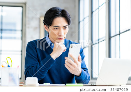Middle-aged man of telework looking at smartphone 85487029