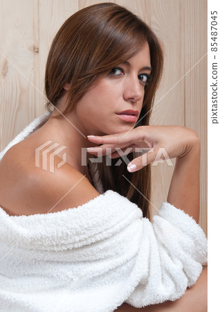 young woman in a sauna or spa after a treatment with her bathrobe young woman in a sauna or spa after a treatment with her bathrobe 85487045