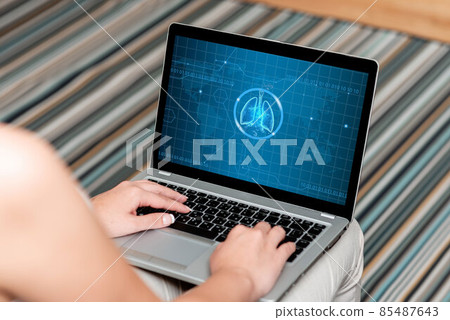 Woman Sitting With Laptop Upper Back View Actively Accomplishing Work From Home. Girl Busy Typing Inside Clean Wide House Finishing Her Remote Job Projects. 85487643