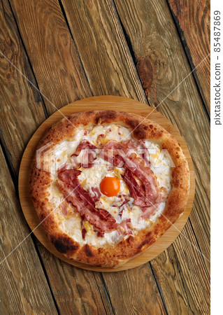 Carbonara pizza with bacon and egg on wooden background Carbonara pizza with bacon and egg on wooden background 85487869