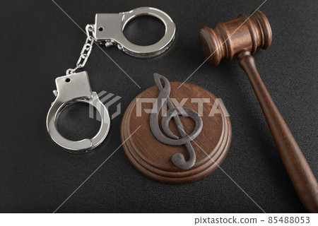 Treble clef sign and handcuffs. Illegal use of someone elses music. Copyright infringement. Music Licensing. Treble clef sign and handcuffs. Illegal use of someone elses music. Copyright infringement. Music Licensing. 85488053