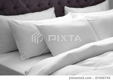 Modern bed with soft pillows in room 85488748