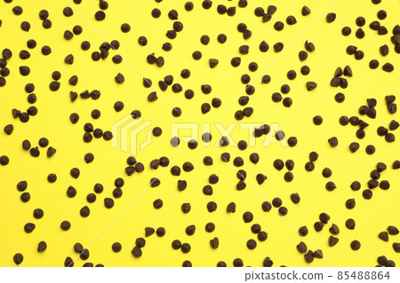 Delicious chocolate chips on yellow background, top view Delicious chocolate chips on yellow background, top view 85488864