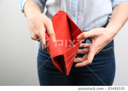 Woman showing empty wallet on light background, closeup Woman showing empty wallet on light background, closeup 85489195