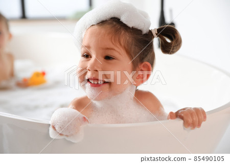 Cute little girl taking bubble bath at home 85490105