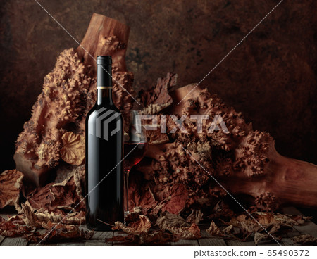 Bottle and glass of red wine on an old wooden table. Bottle and glass of red wine on an old wooden table. 85490372