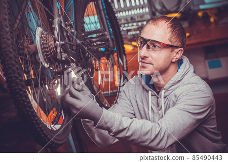 bike mechanic repairs bicycle in workshop 85490443