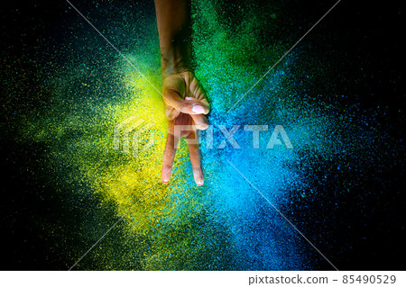 Female hand and explosion of colored, neoned powder on black studio background with copy space. Magazine cover, wallpaper design Female hand and explosion of colored, neoned powder on black studio background with copy space. Magazine cover, wallpaper design 85490529