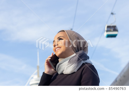 Lovely smiling Arabic woman with mobile phone 85490763