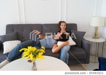 Young mother and teen daughter trying on shoes and choosing clothes together Young mother and teen daughter trying on shoes and choosing clothes together 85491021