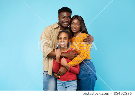 African American man hugging his wife and smiling daughter African American man hugging his wife and smiling daughter 85492586