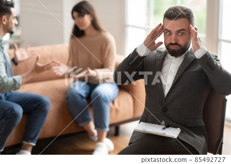 Couple arguing at therapy session, male therapist grabbing head 85492727