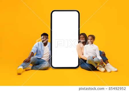 Black family showing white empty smartphone screen leaning on display Black family showing white empty smartphone screen leaning on display 85492952