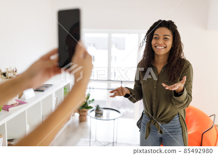 Cheerful black woman filming video on cellphone 85492980