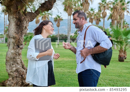 Middle aged business colleagues talking in the park Middle aged business colleagues talking in the park 85493295