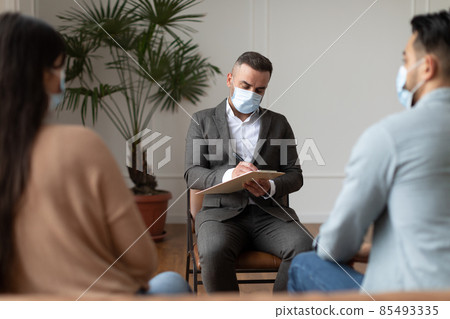 Couple having therapy session with therapist, psychologist writing 85493335