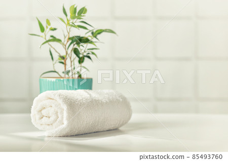 Bathroom accessories on white bathroom countertop against tile wall 85493760