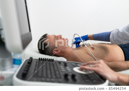 Doctor using ultrasound machine to scan heart of a male patient. Cardiologist makes a patient an echocardiographic test in a clinic. Patient under ultrasound examination in the hospital Doctor using ultrasound machine to scan heart of a male patient. Cardiologist makes a patient an echocardiographic test in a clinic. Patient under ultrasound examination in the hospital 85494254