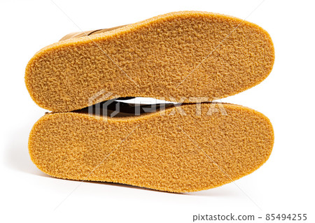 non-slip outsoles of two brown leather winter boots on a white background 85494255