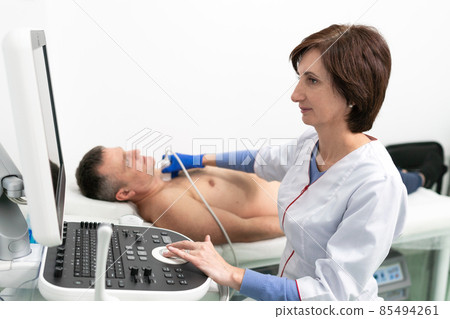 Doctor using ultrasound machine to scan heart of a male patient. Cardiologist makes a patient an echocardiographic test in a clinic. Patient under ultrasound examination in the hospital Doctor using ultrasound machine to scan heart of a male patient. Cardiologist makes a patient an echocardiographic test in a clinic. Patient under ultrasound examination in the hospital 85494261