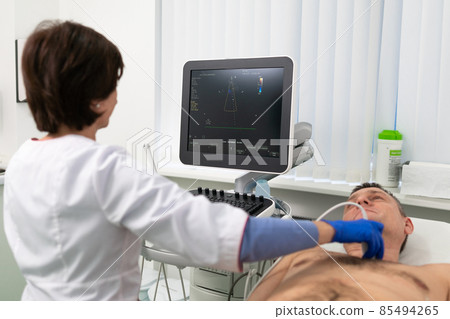 Doctor using ultrasound machine to scan heart of a male patient. Cardiologist makes a patient an echocardiographic test in a clinic. Patient under ultrasound examination in the hospital Doctor using ultrasound machine to scan heart of a male patient. Cardiologist makes a patient an echocardiographic test in a clinic. Patient under ultrasound examination in the hospital 85494265