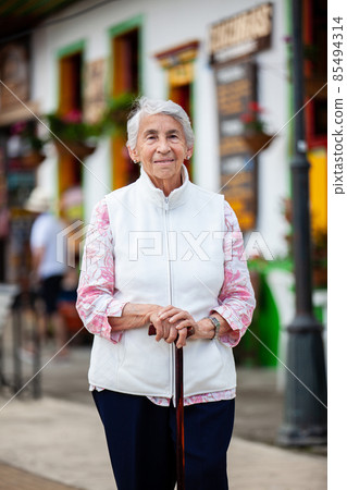 Senior woman at a traditional colorful street in the beautiful colonial town of Salento in the region of Quindio in Colombia 85494314