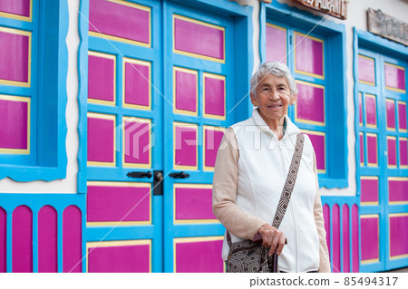 Senior woman at a traditional colorful street in the beautiful colonial town of Salento in the region of Quindio in Colombia 85494317
