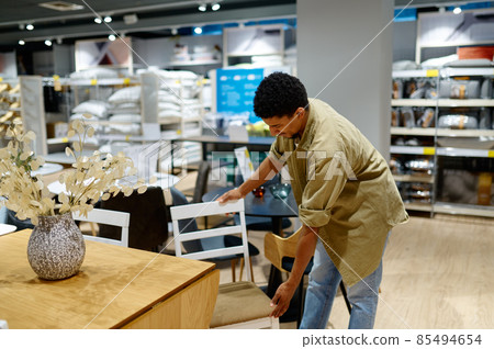 Man is buying folding chair for garden 85494654