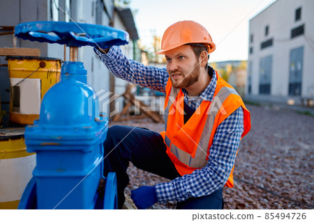 Construction worker checking industrial manufacturer gate valve 85494726